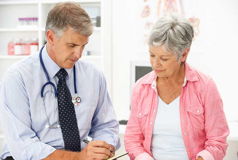 A physician reviewing notes with a senior patient.